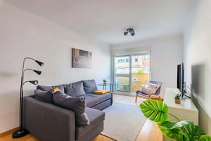 Gray sectional sofa floor lamp artwork and balcony living room at Avenida Marechal Francisco da Costa Gomes in Lisbon Student Accommodation