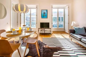 Dining table chairs TV black leather sofa living room at Praça Restauradores in Lisbon Student Accommodation