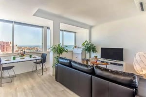 Dining table sofa TV and ocean view living room at Rua da Verónica in Lisbon Student Accommodation