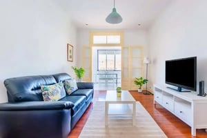 Black leather sofa white coffee table television living room at Avenida Almirante Reis in Lisbon Student Accommodation