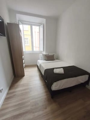 Bed with wardrobe and window bedroom at Room in a 6-bedroom apartment in Calçada Poço dos Mouros, Lisboa - Room 1 in Lisbon Student Accommodation