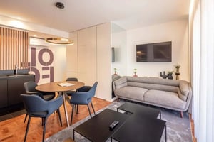 Dining table chairs sofa coffee tables television living room at T2 nas Avenidas Novas — Conforto, Serviços incluídos e a dois Passos da Gulbenkian 1A in Lisbon Student Accommodation