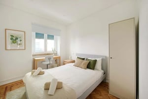 Bed desk towels framed art and wardrobe bedroom at Room in a 4BDR apartment in Lisbon | Room 1 in Lisbon Student Accommodation
