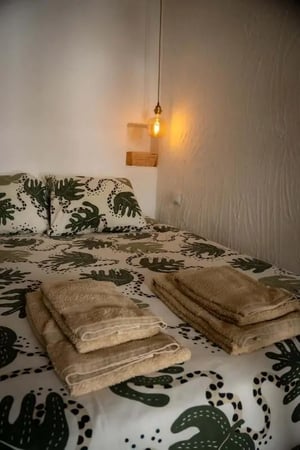 Bed with patterned bedding and towels bedroom at T0 apartment in Alfama in Lisbon Student Accommodation