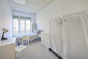 Bed desk chair and two white wardrobes bedroom at Casa Elias IX - Room 1 in Lisbon Student Accommodation