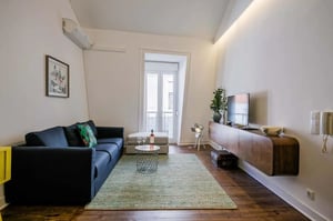 Dark sofa with pillows rug and TV living room at Apartment in Rua da Fé, Lisboa for 70 m² with 2 bedrooms in Lisbon Student Accommodation