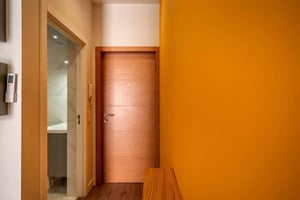 Wooden door and view into tiled bathroom at Apartment in Rua Doutor Álvaro de Castro, Lisboa for 36 m² in Lisbon Student Accommodation