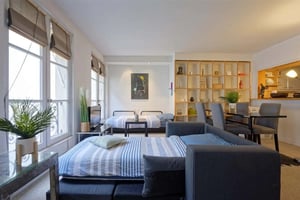 Beds with blue striped bedding and grey sofa Living room at Apartment in Rue Vieille du Temple, Paris for 42 m² in Paris Student Accommodation