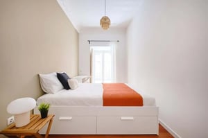 Bed with orange throw and pillows bedroom at Bedroom in a 6-Bedroom Apartment in Rua de São Bento, Lisbon - Room 1 in Lisbon Student Accommodation