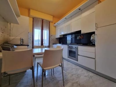 Dining table chairs oven and cabinets kitchen at Single bedroom, with balcony, in 6-bedroom apartment in Siena Student Accommodation