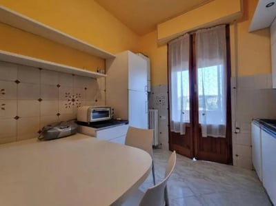 Table microwave appliance and chairs kitchen at Single Bedroom in Shared Apartment in Siena in Siena Student Accommodation