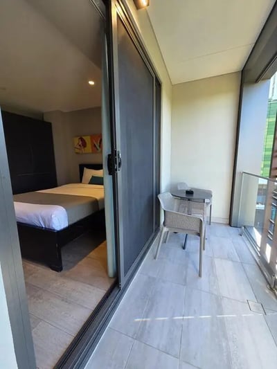 Bed chairs table balcony exterior at Sydney Student Living Top Ryde in Sydney Student Accommodation