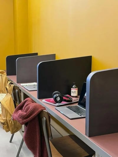 Desks with laptops headphones and backpacks study area at Parklands in Dundee Student Accommodation