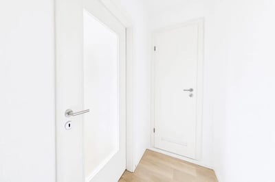 Hallway with two white doors and wooden floor hallway at Welcoming studio in Grünau-Nord in Leipzig Student Accommodation