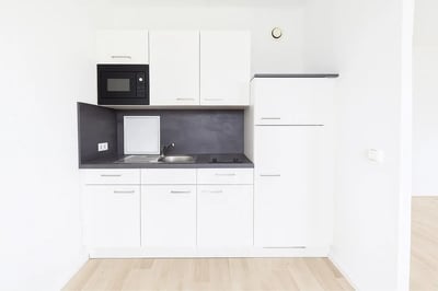 White cabinets microwave sink stovetop refrigerator kitchen at Welcoming studio in Grünau-Nord in Leipzig Student Accommodation