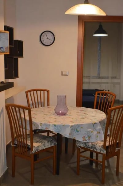 Round table with chairs and vase dining area at Appartamento di due camere da letto in Turin Student Accommodation