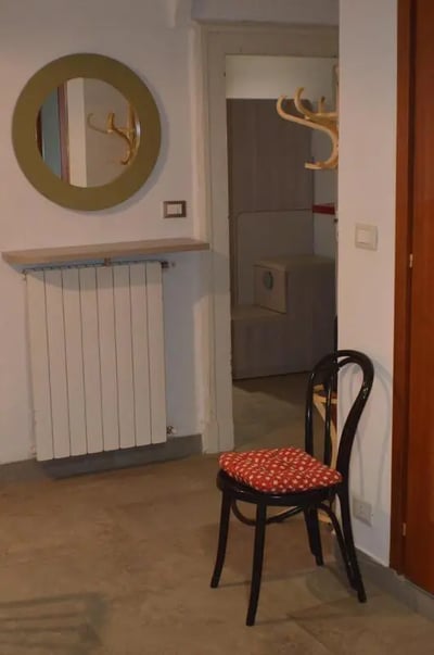 Round mirror radiator chair and coat rack entryway at Appartamento di due camere da letto in Turin Student Accommodation