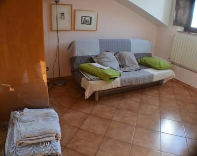 Sofa with pillows framed art floor lamp living room at Bright studio close to Porta Palatina in Turin Student Accommodation