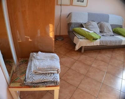 Sofa with cushions and folded towels living room at Bright studio close to Porta Palatina in Turin Student Accommodation