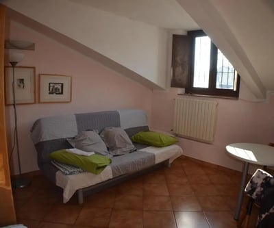 Sofa framed pictures floor lamp round table living room at Bright studio close to Porta Palatina in Turin Student Accommodation