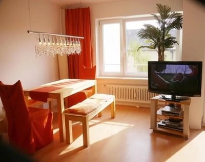 Dining table chairs bench television living area at Admirable and bright studio in Charlottenburg in Berlin Student Accommodation