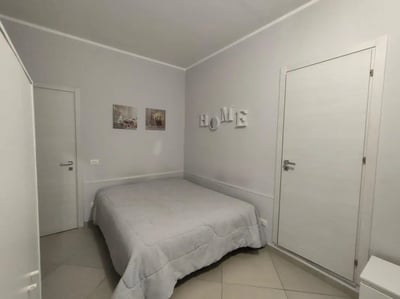 Bed with white bedding and wall decor bedroom at Comfortable and bright Studio next to Stazione Centrale di Palermo in Palermo Student Accommodation