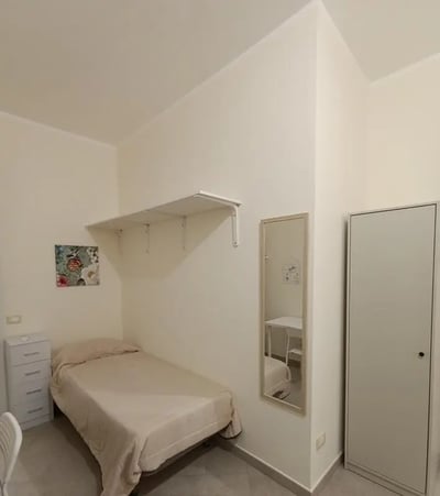 Bed dresser shelf mirror closet bedroom at Comfortable studio close to Università di Palermo in Palermo Student Accommodation