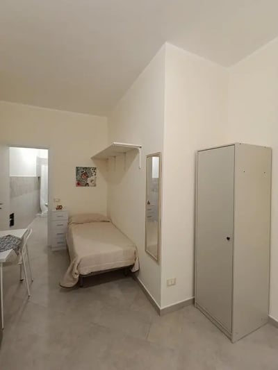 Bed wardrobe dresser mirror bedroom at Comfortable studio close to Università di Palermo in Palermo Student Accommodation