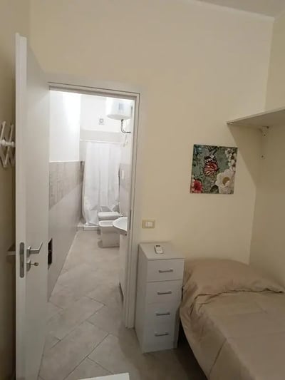 Bed dresser and bathroom visible bedroom interior at Comfortable studio close to Università di Palermo in Palermo Student Accommodation