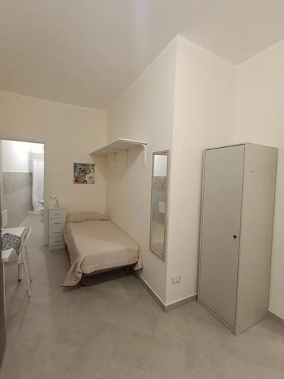 Bed dresser mirror wardrobe bedroom at Comfortable studio close to Università di Palermo in Palermo Student Accommodation