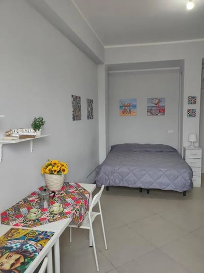 Bed with colorful table and sunflowers bedroom at Cozy and comfortable studio next to Palermo's central station in Palermo Student Accommodation