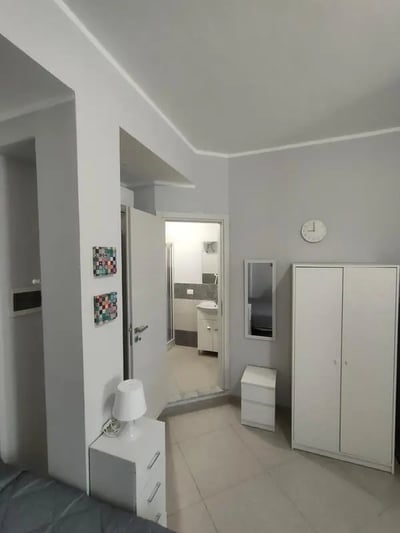 Wardrobe nightstand lamp and open bathroom bedroom at Cozy and comfortable studio next to Palermo's central station in Palermo Student Accommodation