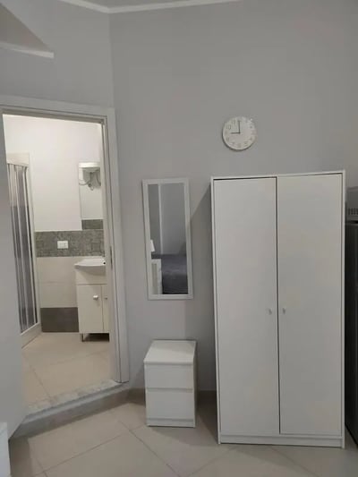 Wardrobe nightstand mirror and bathroom bedroom at Cozy and comfortable studio next to Palermo's central station in Palermo Student Accommodation