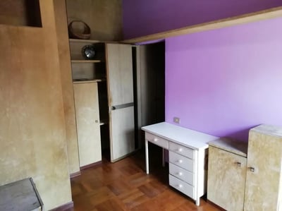 Desk shelves and closet with purple wall study area at Single bedroom "fil rouge", with balcony, in 5-bedroom apartment in Turin Student Accommodation
