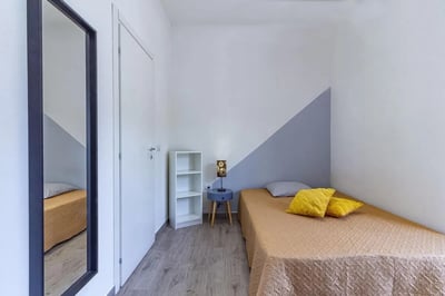 Bed with yellow pillows and side table bedroom at Double Ensuite Bedroom in a 6-bedroom flat near Vanni Stadium in Sassari Student Accommodation