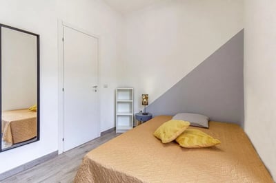Bed with pillows and mirror Bedroom at Double Ensuite Bedroom in a 6-bedroom flat near Vanni Stadium in Sassari Student Accommodation