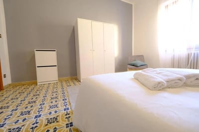 White folded towels on bed wardrobe shoe cabinet bedroom at Delightful double bedroom in the heart of Sassari in Sassari Student Accommodation
