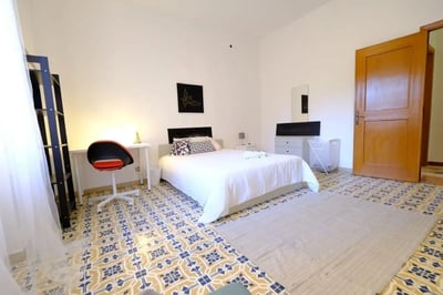 Bed desk chair rug and decorative floor bedroom at Delightful double bedroom in the heart of Sassari in Sassari Student Accommodation
