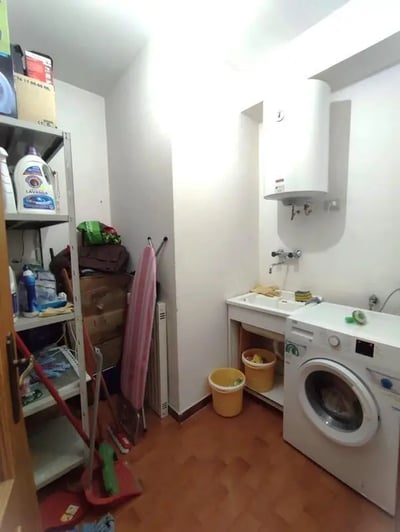 Washing machine sink and cleaning supplies laundry room at Homely double bedroom near the Orti di San Pietro park in Sassari Student Accommodation