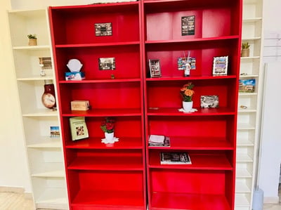 Red shelves with books and decor bedroom shelving at Apartment a Few minutes from the Center and Colosseum in Rome Student Accommodation