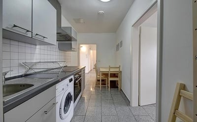 Modern kitchen with white cabinets sink washer dining table kitchen at Elegant single bedroom near Bad Cannstatt train station in Stuttgart Student Accommodation