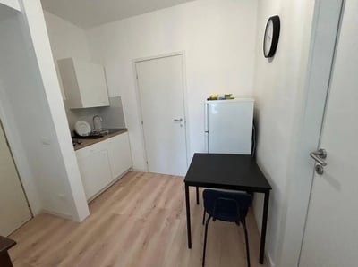 Kitchenette with fridge table and chair kitchen at Minimalist one-bedroom apartment in the center of Bergamo: quiet, bright, and with utilities included in Bergamo Student Accommodation