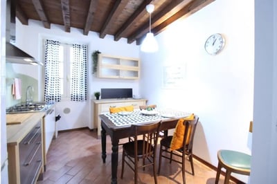 Dining table and chairs with polka dot cloth kitchen area at Charming single bedroom near Università Cattolica del Sacro Cuore in Brescia Student Accommodation