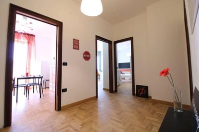 Dining area and hallway with art and flowers. at Posh double bedroom near the Brescia train station in Brescia Student Accommodation