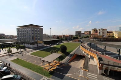 Gray apartment building with green lawn exterior at Posh double bedroom near the Brescia train station in Brescia Student Accommodation