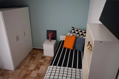 Wardrobe bed with colorful pillows and shelving bedroom at Pretty nice single bedroom in Borgo Trento in Brescia Student Accommodation