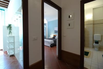 Tiled bathroom with toilet and bedroom with bed. at Sublime single bedroom near Università Cattolica del Sacro Cuore in Brescia Student Accommodation