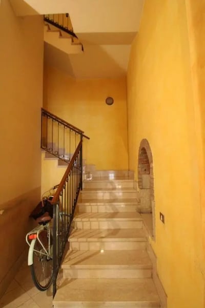 Bike on stairs yellow hallway interior hallway at Brilliant single bedroom near Università Cattolica del Sacro Cuore in Brescia Student Accommodation