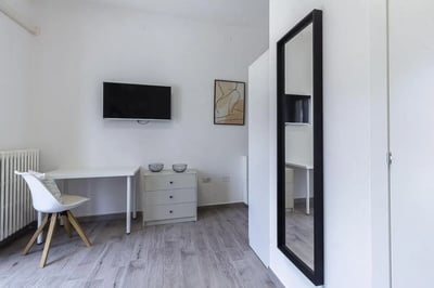 White desk dresser chair mirror artwork television bedroom at Spacious single Ensuite Bedroom near Vanni Stadium in Sassari Student Accommodation