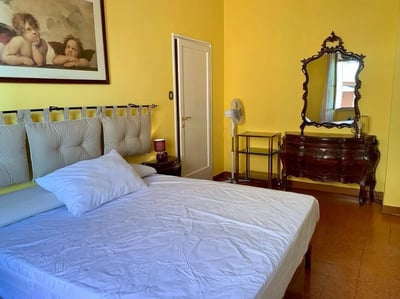 Bed pillows dresser mirror fan bedroom at Large double bedroom close to the Trastevere train station in Rome Student Accommodation
